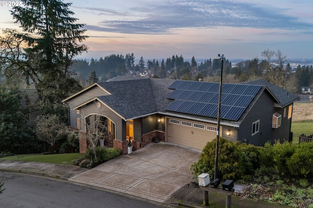 view of front facade featuring a garage and solar panels