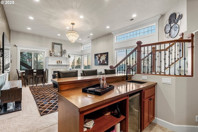 kitchen with sink, a healthy amount of sunlight, wine cooler, a chandelier, and decorative light fixtures