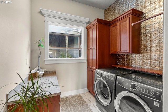 laundry area featuring cabinets, washer and dryer, and light tile patterned flooring