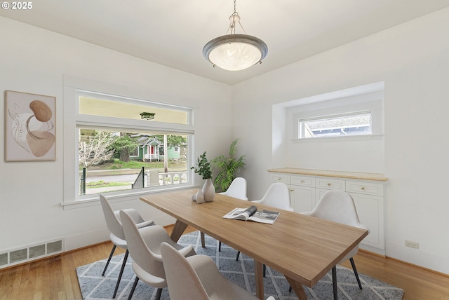 dining room featuring a wealth of natural light, visible vents, light wood-type flooring, and baseboards