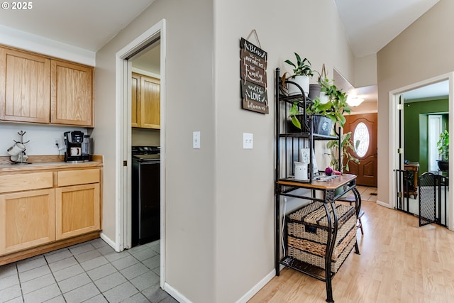 1278 Winery Ln, Eugene, OR 97404 - kitchen with light brown cabinets, washer / clothes dryer, light countertops, light wood-style flooring, and baseboards