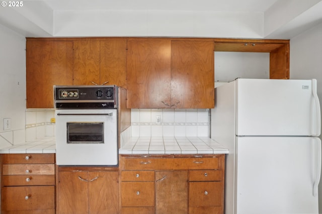 4242 SW Admiral St, Portland, OR 97221 - kitchen featuring white appliances, backsplash, and brown cabinetry