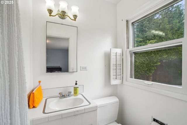 4242 SW Admiral St, Portland, OR 97221 - half bathroom with a chandelier, vanity, and toilet