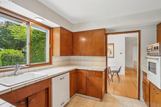 4242 SW Admiral St, Portland, OR 97221 - kitchen with white appliances, a sink, healthy amount of natural light, and brown cabinetry
