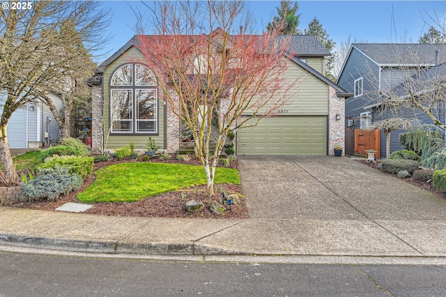 traditional-style house with an attached garage, fence, concrete driveway, and brick siding