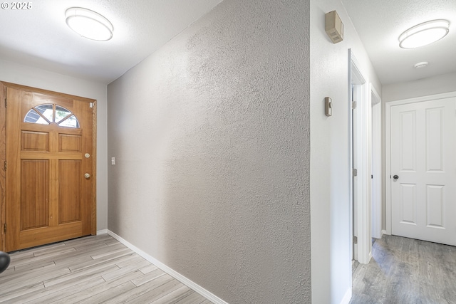 4004 Ginkgo Ave, Tillamook, OR 97141 - foyer entrance featuring light wood-style floors, a textured wall, and baseboards