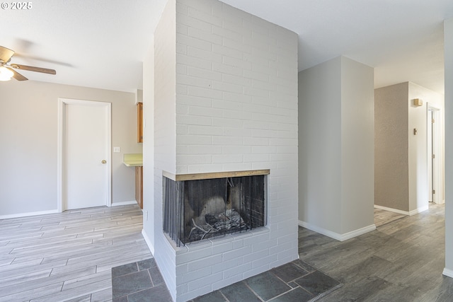 4004 Ginkgo Ave, Tillamook, OR 97141 - unfurnished living room featuring a ceiling fan, wood finished floors, a fireplace, and baseboards