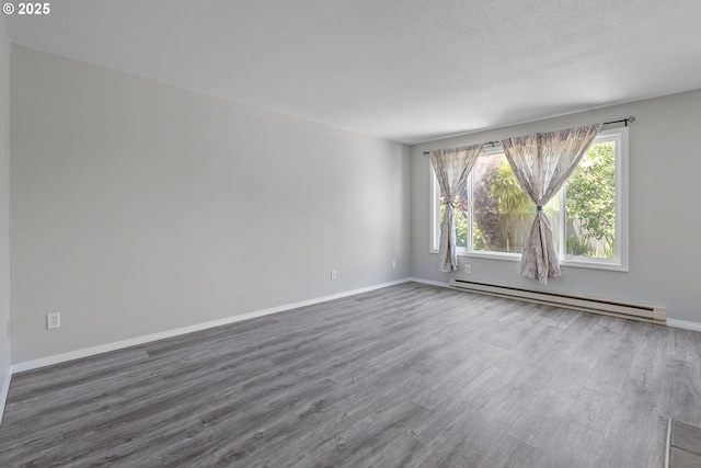 4004 Ginkgo Ave, Tillamook, OR 97141 - unfurnished room featuring baseboard heating, dark wood-style floors, and baseboards