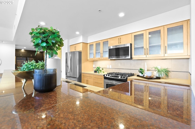 700 Washington St Unit 925, Vancouver, WA 98660 - kitchen with stainless steel appliances, recessed lighting, glass insert cabinets, backsplash, and light brown cabinets