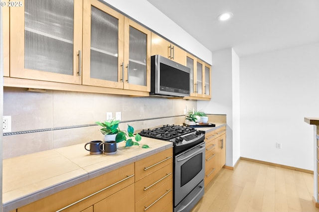 700 Washington St Unit 925, Vancouver, WA 98660 - kitchen featuring appliances with stainless steel finishes, glass insert cabinets, light wood-type flooring, recessed lighting, and baseboards