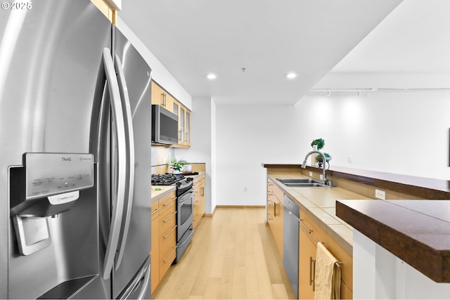 700 Washington St Unit 925, Vancouver, WA 98660 - kitchen with stainless steel appliances, a sink, light wood-style flooring, recessed lighting, and glass insert cabinets