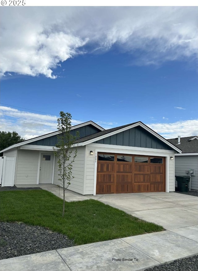 843 NE 11th St, Hermiston, OR 97838 - view of front of property featuring board and batten siding, a garage, a front lawn, and driveway
