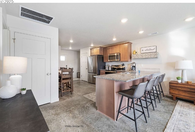 843 NE 11th St, Hermiston, OR 97838 - kitchen featuring appliances with stainless steel finishes, a sink, recessed lighting, a peninsula, and a breakfast bar area