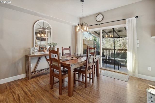 dining space featuring hardwood / wood-style flooring and an inviting chandelier