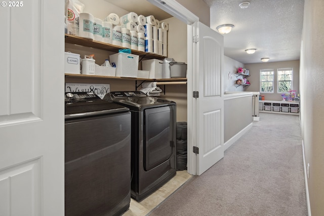 laundry room featuring light colored carpet, independent washer and dryer, and a textured ceiling