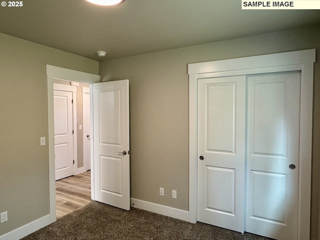 unfurnished bedroom with a closet, carpet flooring, and baseboards