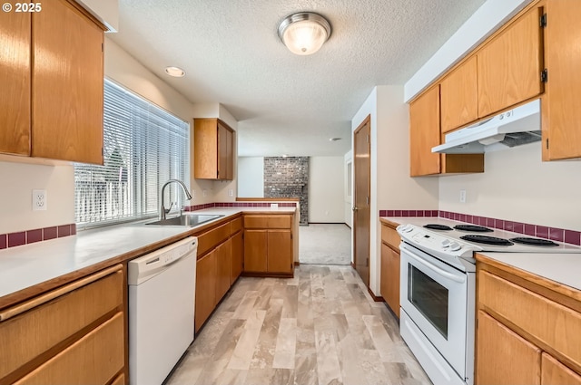 kitchen featuring white appliances, light wood-type flooring, a textured ceiling, sink, and kitchen peninsula