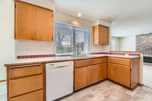 kitchen featuring sink, kitchen peninsula, a textured ceiling, and white dishwasher