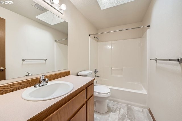 full bathroom featuring toilet, a skylight, vanity, and shower / bathing tub combination