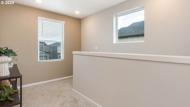 hall with light colored carpet