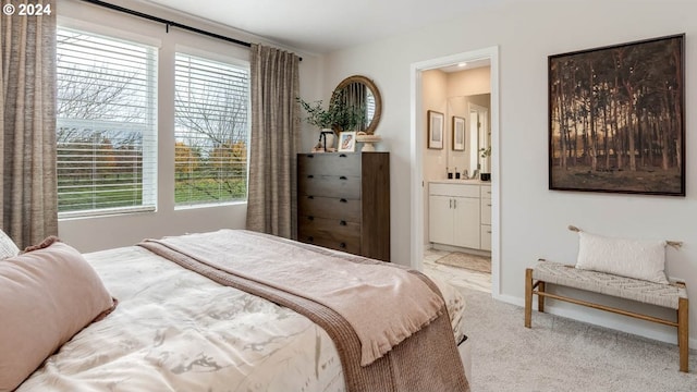 carpeted bedroom featuring multiple windows and ensuite bath