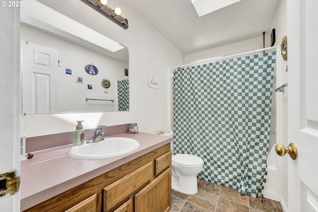 full bath featuring toilet, stone finish floor, a shower with shower curtain, and vanity