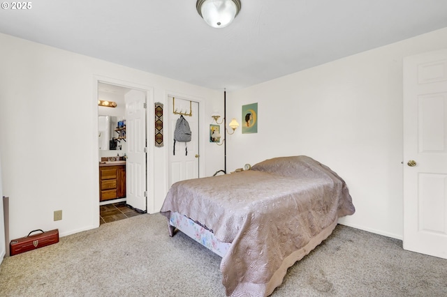 carpeted bedroom with baseboards and ensuite bath
