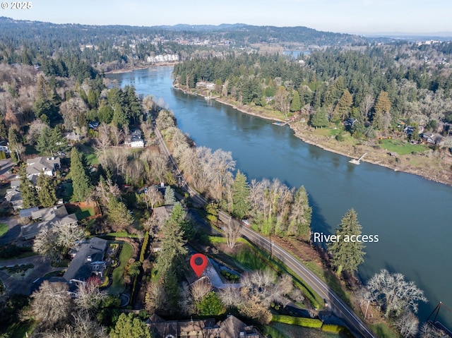 drone / aerial view with a forest view and a water view