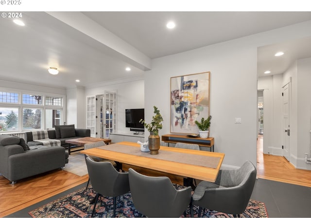 dining space featuring ornamental molding and light parquet flooring