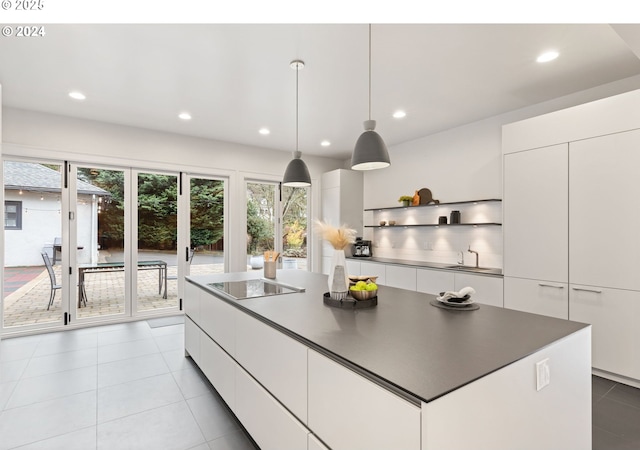 kitchen with white cabinetry, decorative light fixtures, light tile patterned floors, black electric cooktop, and a kitchen island