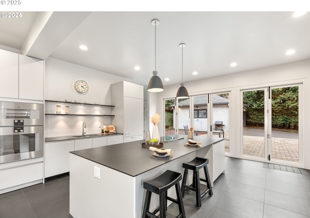 kitchen with sink, white cabinets, and decorative light fixtures