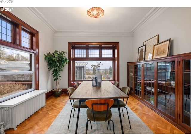 dining space with radiator, ornamental molding, and light parquet floors