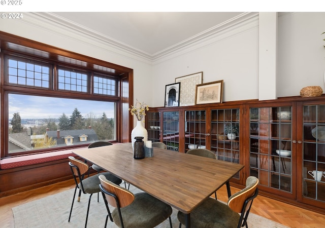 dining room with ornamental molding and light parquet flooring