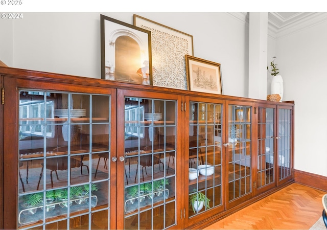 interior details with crown molding and parquet flooring