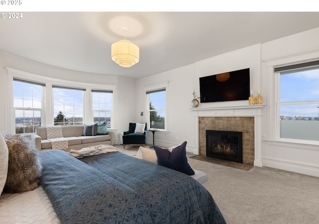 carpeted bedroom with a tiled fireplace