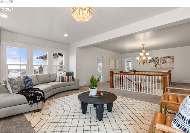 carpeted living room with a notable chandelier