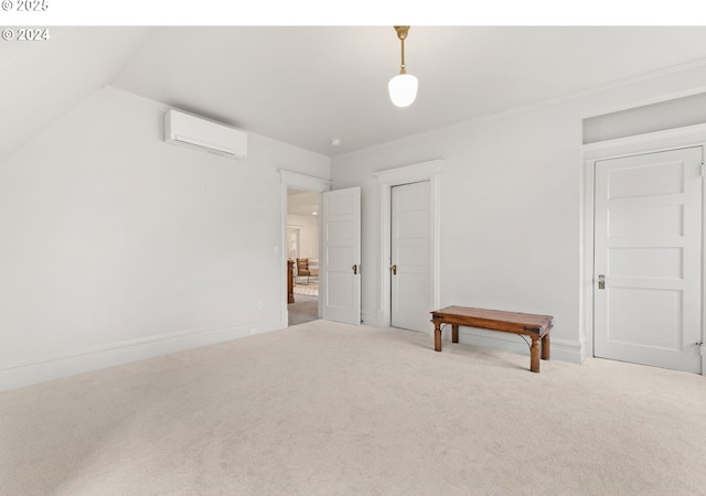 spare room with lofted ceiling, a wall mounted air conditioner, and carpet floors