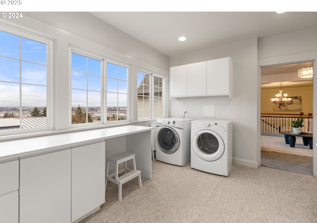 clothes washing area with an inviting chandelier, cabinets, light carpet, and washer and dryer