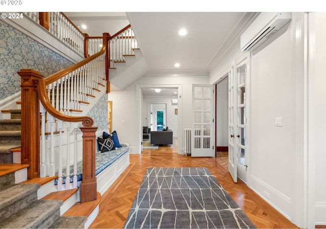 foyer featuring a wall mounted air conditioner, crown molding, french doors, and light parquet floors