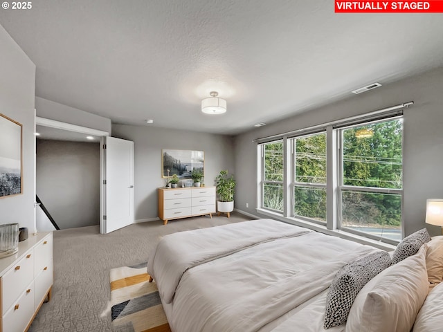 bedroom with visible vents, baseboards, and light carpet