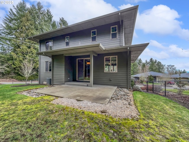 back of property with a patio area, a lawn, and fence