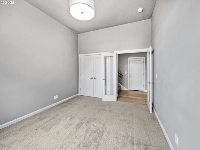 unfurnished bedroom with a closet, baseboards, and carpet