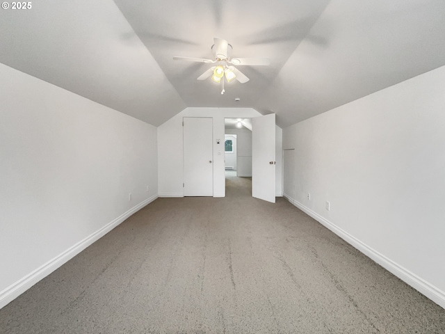 additional living space featuring baseboards, light carpet, ceiling fan, and vaulted ceiling