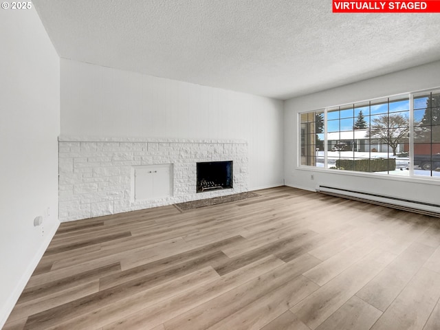 unfurnished living room featuring a brick fireplace, wood finished floors, baseboards, and baseboard heating