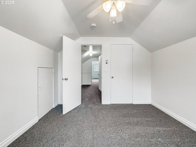 bonus room with vaulted ceiling, a ceiling fan, dark colored carpet, and baseboards