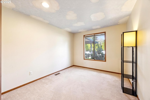 unfurnished room with carpet floors, visible vents, a textured ceiling, and baseboards