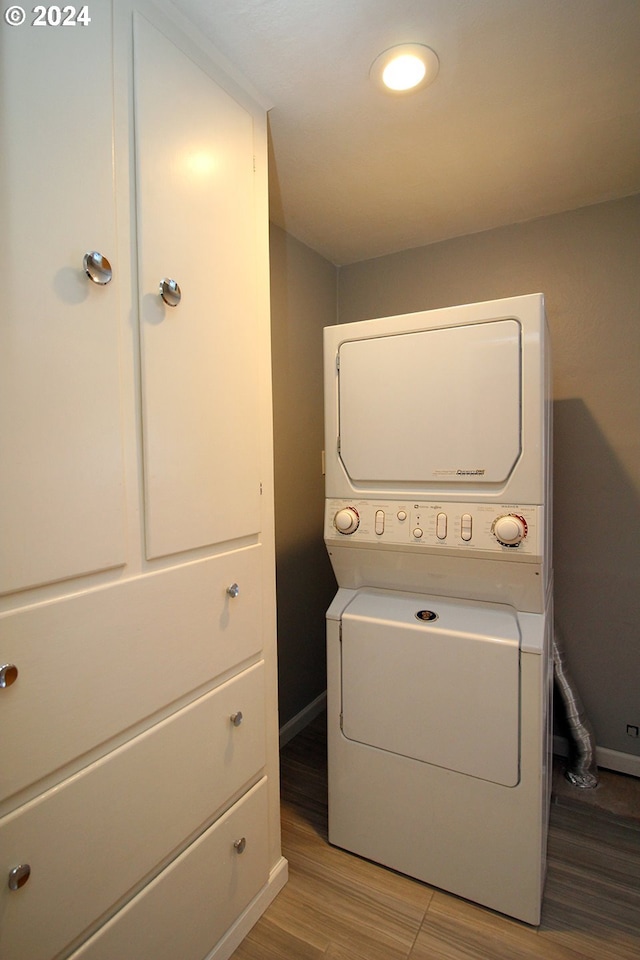 2309 SE 90th Ave, Portland, OR 97216 - laundry area featuring stacked washer and clothes dryer, baseboards, and wood finished floors
