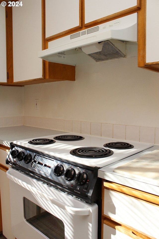2309 SE 90th Ave, Portland, OR 97216 - kitchen with white range with electric stovetop, under cabinet range hood, light countertops, and white cabinets