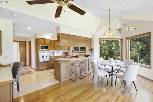 4719 Westwood Dr, Hood River, OR 97031 - dining area featuring light wood finished floors, vaulted ceiling, ceiling fan, a chandelier, and recessed lighting
