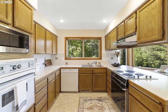 4719 Westwood Dr, Hood River, OR 97031 - kitchen with white appliances, under cabinet range hood, a sink, light countertops, and brown cabinetry
